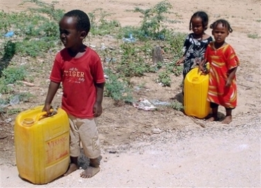 Displaced Somali children carry plastic cans in search of water in a camp outside Mogadishu Saturday, Nov. 17, 2007. A roadside bomb hit a truck carrying soldiers in Somalia's capital Saturday, killing two people and wounding six, a witness said, and an African Union peacekeeping base was attacked in a separate incident . (AP Photo/Abdi Farah Warsameh)